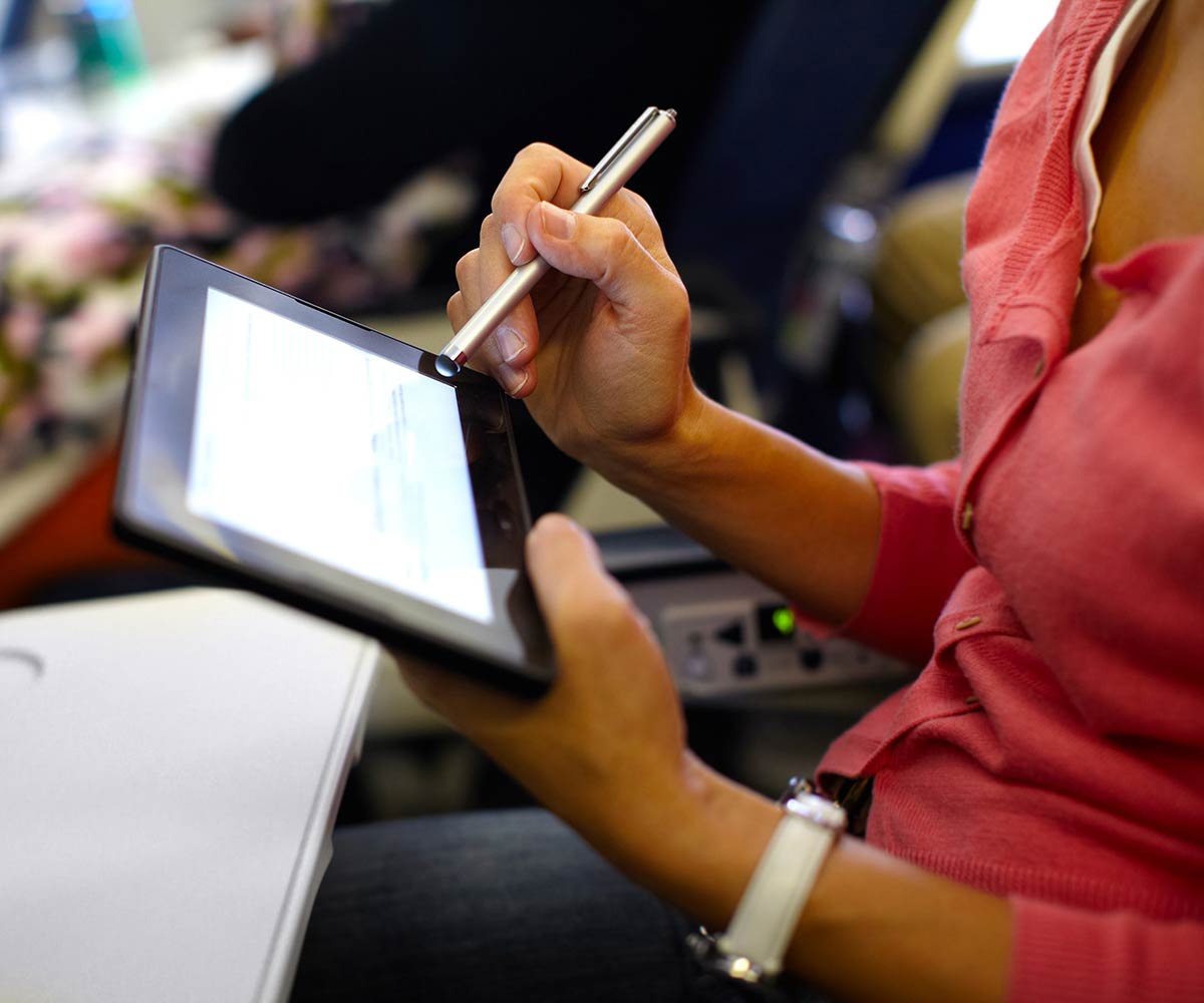 一位女士正在商务班机里使用iPad