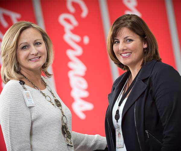 Two female Associates standing in a hallway